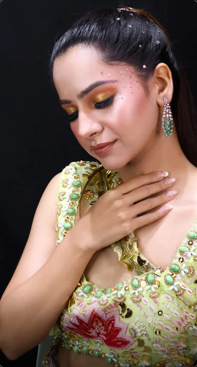 Gold eye makeup with crystal detailing along the temple